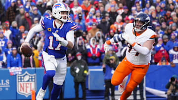 Buffalo Bills QB Josh Allen runs the ball as Denver Broncos DE Zach Allen defends in an AFC wild-card game.