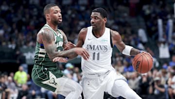 Dallas Mavericks guard Kyrie Irving controls the ball as Milwaukee Bucks guard Damian Lillard.