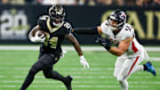 Nov 23, 2025; New Orleans, Louisiana, USA; New Orleans Saints running back Devin Neal (24) carries the ball as Atlanta Falcons linebacker Kaden Elliss (55) defends during the second half at Caesars Superdome. Mandatory Credit: Stephen Lew-Imagn Images