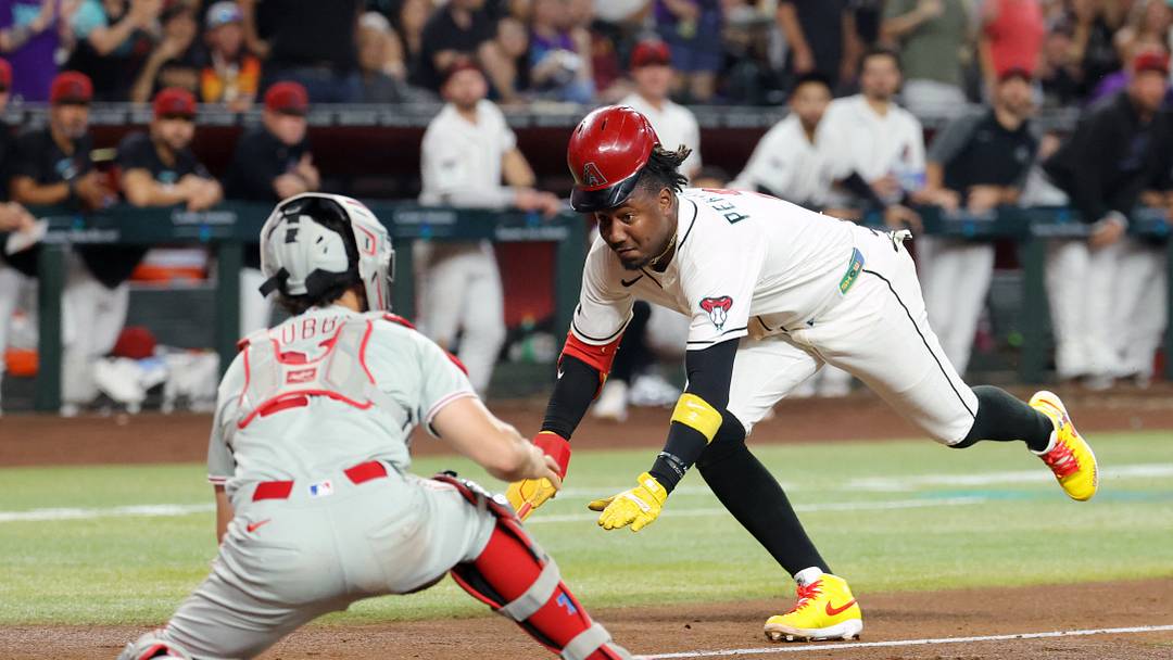 Aug 31, 2026; Phoenix, Arizona, USA; Arizona Diamondbacks base runner Geraldo Perdomo (right) scores against Philadelphia Phillies catcher Garrett Stubbs in the third inning at Chase Field. Mandatory Credit: Mark J. Rebilas-Imagn Images