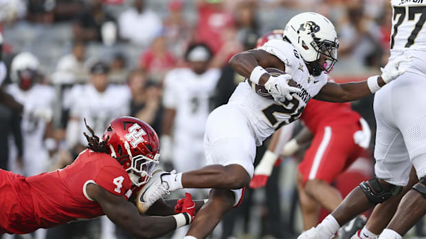 Colorado Buffaloes running back Micah Welch (29) runs with the ball as Houston Cougars linebacker Brandon Mack II (4) attempt