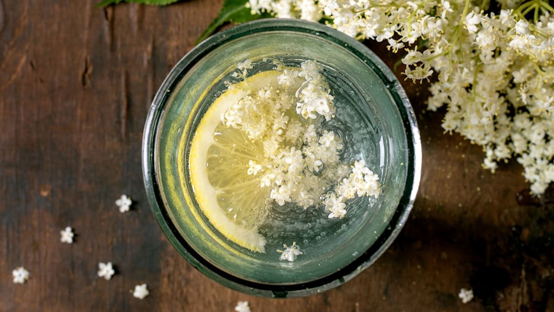 Cup of tea with lemon and flowers in it on a wood table