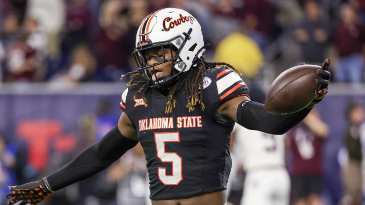 Dec 27, 2023; Houston, TX, USA; Oklahoma State Cowboys safety Kendal Daniels (5)  celebrates his interception against the Texas A&M Aggies in the second half at NRG Stadium. Mandatory Credit: Thomas Shea-USA TODAY Sports