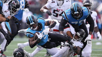 Sep 21, 2025; Charlotte, North Carolina, USA; Carolina Panthers running back Rico Dowdle (5) gets tackled during the first half of a game between Carolina Panthers and the Atlanta Falcons at Bank of America Stadium. Mandatory Credit: Cory Knowlton-Imagn Images