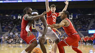 Feb 23, 2025; Los Angeles, California, USA; UCLA Bruins guard Eric Dailey Jr. (3) is defended by Ohio State Buckeyes guard Bruce Thornton (2), center Austin Parks (25) and guard Ques Glover (6) during the second half at Pauley Pavilion presented by Wescom. Mandatory Credit: Robert Hanashiro-Imagn Images