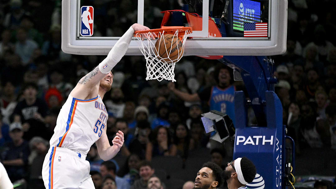 Oct 27, 2025; Dallas, Texas, USA; Oklahoma City Thunder center Isaiah Hartenstein (55) dunks the ball as Dallas Mavericks forward P.J. Washington (25) and forward Anthony Davis (3) look on during the second half at the American Airlines Center. Mandatory Credit: Jerome Miron-Imagn Images