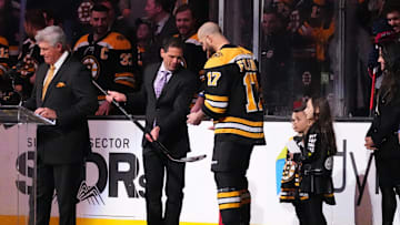 Apr 2, 2022; Boston, Massachusetts, USA; Boston Bruins general Manager Don Sweeney presents Boston Bruins left wing Nick Foligno (17) with a sliver stick to commemorate him playing 1000 games prior to the game against the Columbus Blue Jackets at TD Garden. Mandatory Credit: Gregory Fisher-Imagn Images