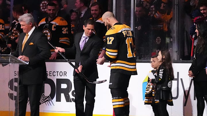 Apr 2, 2022; Boston, Massachusetts, USA; Boston Bruins general Manager Don Sweeney presents Boston Bruins left wing Nick Foligno (17) with a sliver stick to commemorate him playing 1000 games prior to the game against the Columbus Blue Jackets at TD Garden. Mandatory Credit: Gregory Fisher-Imagn Images
