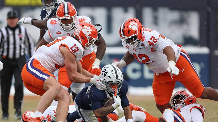 Dec 27, 2025; Bronx, NY, USA; Penn State Nittany Lions running back Corey Smith (24) is tackled by Clemson Tigers defensive end Will Heldt (13) during the first half of the 2025 Pinstripe Bowl at Yankee Stadium. Mandatory Credit: Vincent Carchietta-Imagn Images