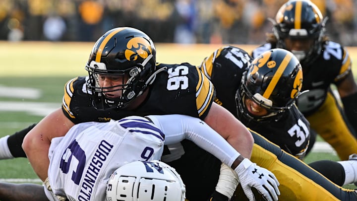 Oct 29, 2022; Iowa City, Iowa, USA; Iowa Hawkeyes defensive lineman Aaron Graves (95) and linebacker Jack Campbell (31) and Northwestern Wildcats wide receiver Malik Washington (6) in action during the game at Kinnick Stadium. Mandatory Credit: Jeffrey Becker-Imagn Images