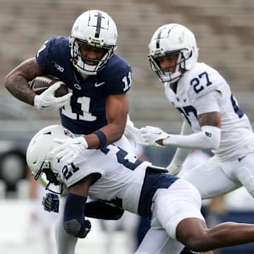 Penn State Nittany Lions wide receiver Kyron Hudson (11) runs with the ball as safety Vaboue Toure (21) goes for the tackle during the Blue-White Game. 