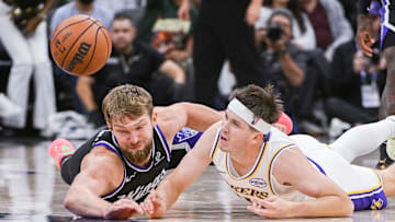 Oct 26, 2025; Sacramento, California, USA; Sacramento Kings forward/center Domantas Sabonis (11) and Los Angeles Lakers guard Austin Reaves (15) fight for possession of the ball during the fourth quarter at Golden 1 Center. Mandatory Credit: Ed Szczepanski-Imagn Images