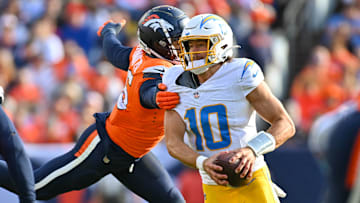 DENVER, CO: Chargers quarterback Justin Herbert (10) is sacked by Broncos linebacker Nik Bonitto (15) during a game between the Denver Broncos and the Los Angeles Chargers at Empower Field at Mile High in Denver, CO on October 13, 2024.