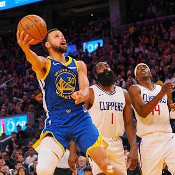 Golden State Warriors guard Stephen Curry (30) scores against Los Angeles Clippers guard James Harden (1), guard Terance Mann (14) during the fourth quarter at Chase Center. 