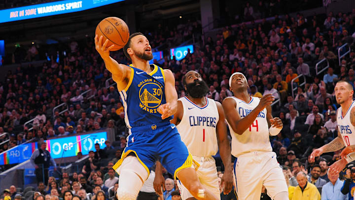 Golden State Warriors guard Stephen Curry (30) scores against Los Angeles Clippers guard James Harden (1), guard Terance Mann (14) during the fourth quarter at Chase Center. 