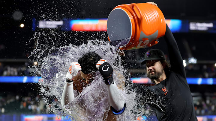 Sep 6, 2024; New York City, New York, USA; New York Mets third baseman Mark Vientos (27) gets a gatorade bath from left fielder Jesse Winker (3) after hitting a walkoff two run home run during the tenth inning against the Cincinnati Reds at Citi Field. Mandatory Credit: Brad Penner-Imagn Images