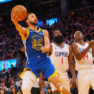 Nov 30, 2023; San Francisco, California, USA; Golden State Warriors guard Stephen Curry (30) scores against Los Angeles Clippers guard James Harden (1), guard Terance Mann (14) during the fourth quarter at Chase Center. 