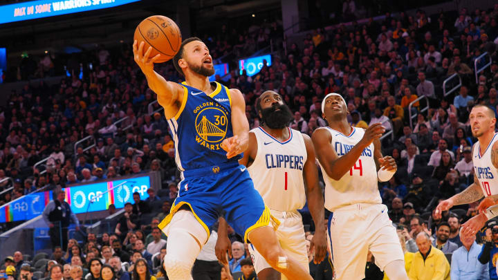 Nov 30, 2023; San Francisco, California, USA; Golden State Warriors guard Stephen Curry (30) scores against Los Angeles Clippers guard James Harden (1), guard Terance Mann (14) during the fourth quarter at Chase Center. 