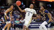 Akron Zips guard Tavari Johnson looks to the basket ahead of Toledo Rockets guard Sonny Wilson during the first half of an NCAA college basketball game in the semifinals of the Mid-American Conference Tournament at Rocket Arena.