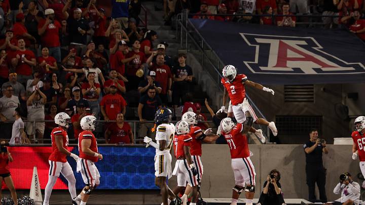 Sep 7, 2024; Tucson, Arizona, USA; Arizona Wildcats wide receiver Jeremiah Patterson (2) celebrates a touchdown with Arizona Wildcats offensive lineman Jonah Savaiinaea (71) during the third quarter against Northern Arizona Lumberjacks at Arizona Stadium. Mandatory Credit: Aryanna Frank-Imagn Images