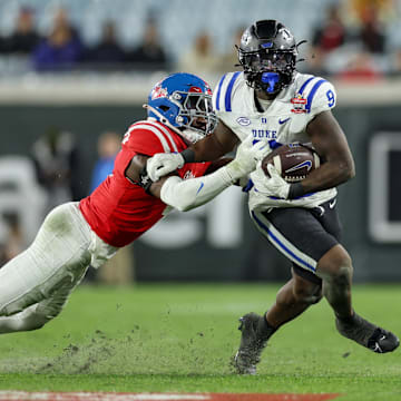 Jan 2, 2025; Jacksonville, FL, USA; Duke Blue Devils running back Jaquez Moore (9) is chased by Mississippi Rebels linebacker Suntarine Perkins (4) in the second quarter during the Gator Bowl at EverBank Stadium. Mandatory Credit: Nathan Ray Seebeck-Imagn Images