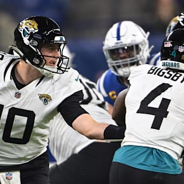 Jan 5, 2025; Indianapolis, Indiana, USA; Jacksonville Jaguars quarterback Mac Jones (10) hands then all off to Jacksonville Jaguars running back Tank Bigsby (4) during the second half against the Indianapolis Colts at Lucas Oil Stadium. Mandatory Credit: Marc Lebryk-Imagn Images