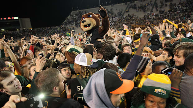 Baylor Bears fans and the mascot celebrate on the field after the game against the Kansas State Wildcats at Floyd Casey Stadi