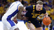 West Virginia Mountaineers guard Tucker DeVries (12) brings the ball up court against pressure from Pittsburgh Panthers guard Damian Dunn (1) during the first half at the Petersen Events Center.