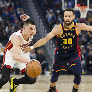 Jan 7, 2025; San Francisco, California, USA; Miami Heat guard Tyler Herro (14) drives past Golden State Warriors guard Stephen Curry (30) during the first quarter at Chase Center. Mandatory Credit: John Hefti-Imagn Images
