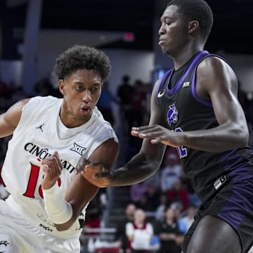 Nov 3, 2025; Cincinnati, Ohio, USA;  Cincinnati Bearcats forward Baba Miller (18) drives to the basket against Western Carolina Catamounts forward Samuel Dada (12) in the first half at Fifth Third Arena. Mandatory Credit: Aaron Doster-Imagn Images