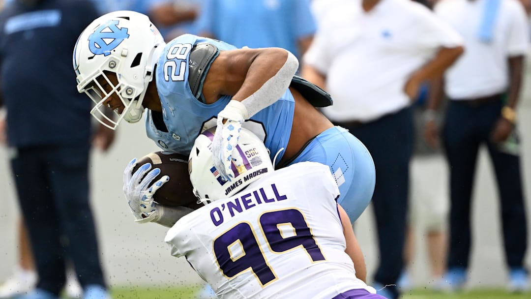 North Carolina Tar Heels running back Omarion Hampton (28) is tackled by James Madison Dukes DL Eric O'Neill (99) 