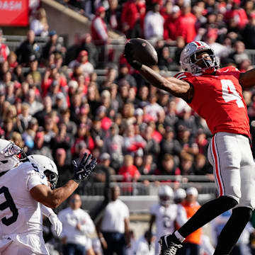 Ohio State Buckeyes wide receiver Jeremiah Smith (4) catches a touchdown pass in front of Penn State Nittany Lions cornerback Elliot Washington II (9) during the NCAA football game at Ohio Stadium in Columbus on Nov. 1, 2025.