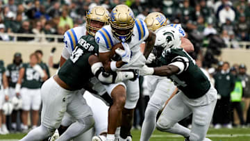 Oct 11, 2025; East Lansing, Michigan, USA; UCLA Bruins running back Jalen Berger (0) runs through the Michigan State defense in the second quarter at Spartan Stadium. Mandatory Credit: Brendan Mullin-Imagn Images