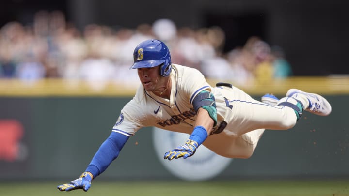 Seattle Mariners left fielder Dylan Moore (25) dives into third base for a triple against the Houston Astros during the second inning at T-Mobile Park on July 21.