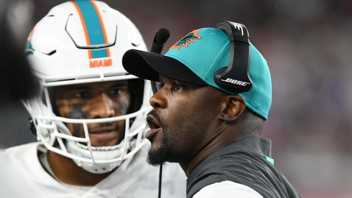 Sep 12, 2021; Foxborough, Massachusetts, USA; Miami Dolphins head coach Brian Flores talks with quarterback Tua Tagovailoa (1) during a timeout during the second half of a game against the New England Patriots at Gillette Stadium. Mandatory Credit: Brian Fluharty-USA TODAY Sports