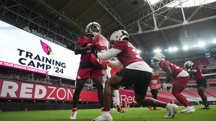 Arizona Cardinals running backs including Emari Demercado (31) warm up during training camp at State Farm Stadium in Glendale on July 25, 2024.