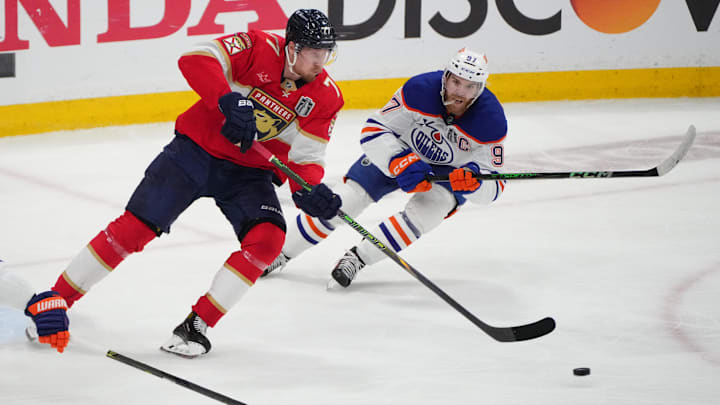 Jun 17, 2025; Sunrise, Florida, USA; Florida Panthers defenseman Niko Mikkola (77) and Edmonton Oilers center Connor McDavid (97) skate after the puck during the second period in game six of the 2025 Stanley Cup Final at Amerant Bank Arena. Mandatory Credit: Jim Rassol-Imagn Images