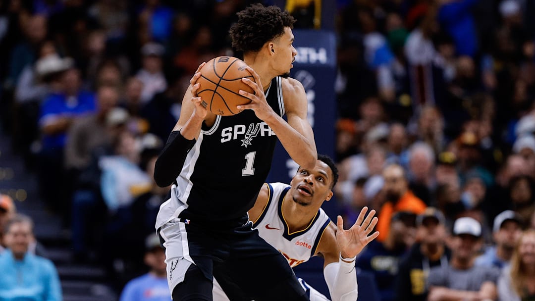 Jan 3, 2025; Denver, Colorado, USA; San Antonio Spurs center Victor Wembanyama (1) controls the ball as Denver Nuggets guard Russell Westbrook (4) guards in the third quarter at Ball Arena.