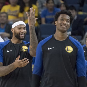 September 29, 2018; Oakland, CA, USA; Golden State Warriors forward Kevon Looney (5), center DeMarcus Cousins (0), center Damian Jones (15), and forward Kevin Durant (35) talk during a timeout in the fourth quarter against the Minnesota Timberwolves at Oracle Arena. The Timberwolves defeated the Warriors 114-110. Mandatory Credit: Kyle Terada-USA TODAY Sports