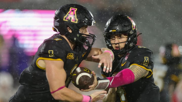 Dec 16, 2023; Orlando, FL, USA;  Appalachian State Mountaineers quarterback Joey Aguilar (4) hands off to Appalachian State Mountaineers running back Anderson Castle (1) against the Miami (OH) Redhawks in the third quarter in the third quarter during the Avocados from Mexico Cure Bowl at FBC Mortgage Stadium. Mandatory Credit: Nathan Ray Seebeck-USA TODAY Sports