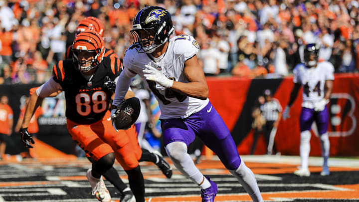 Baltimore Ravens safety Kyle Hamilton runs with the ball against Cincinnati Bengals tight end Mike Gesicki.