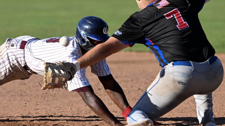 Cam Collier of Cotuit dives back to first.