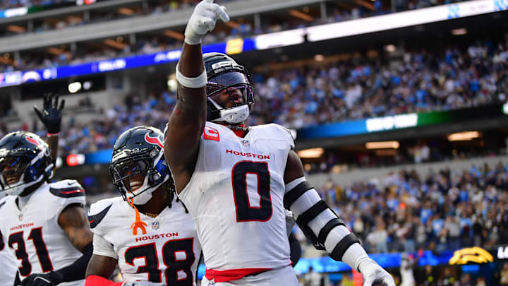 Dec 27, 2025; Inglewood, California, USA;  Houston Texans linebacker Azeez al-Shaair (0) reacts with safety K'Von Wallace (38) after making an interception against the Los Angeles Chargers during the first half at SoFi Stadium. Mandatory Credit: Gary A. Vasquez-Imagn Images
