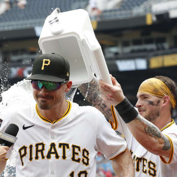 Pittsburgh Pirates catcher Yasmani Grandal (6) dumps water on left fielder Bryan Reynolds (10) after defeating the Cincinnati Reds at PNC Park. Reynolds hit a solo home run for the only run of the game. The Pirates shutout the Reds 1-0 on June 19.