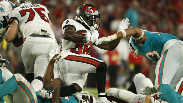 Aug 13, 2022; Tampa, Florida, USA; Tampa Bay Buccaneers running back Kenjon Barner (38) runs with the ball as Miami Dolphins defensive tackle Benito Jones (95) tackles during the second half at Raymond James Stadium. Mandatory Credit: Kim Klement-USA TODAY Sports