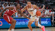 Dec 3, 2024; Coral Gables, Florida, USA; Miami Hurricanes guard Matthew Cleveland (0) drives to the basket past Arkansas Razorbacks guard Johnell Davis (1) during the second half at Watsco Center. Mandatory Credit: Sam Navarro-Imagn Images