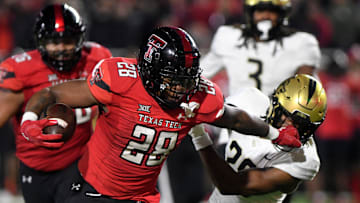 Texas Tech's running back Tahj Brooks (28) stiff-arms UCF's defensive back William Wells (29) during the Big 12 football game, Saturday, Nov. 18, 2023, at Jones AT&T Stadium.