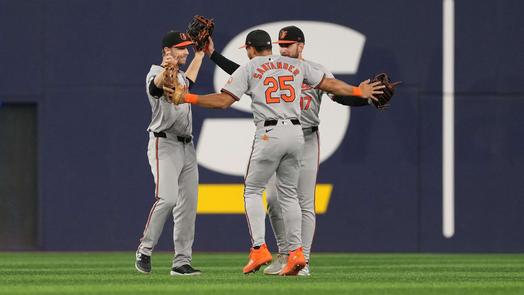 Aug 7, 2024; Toronto, Ontario, CAN; Baltimore Orioles left ielder Austin Slater (15) and center fielder Colton Cowser (17) and right fielder Anthony Santander (25) celebrate the win against the Toronto Blue Jays at the end of he ninth inning at Rogers Centre.