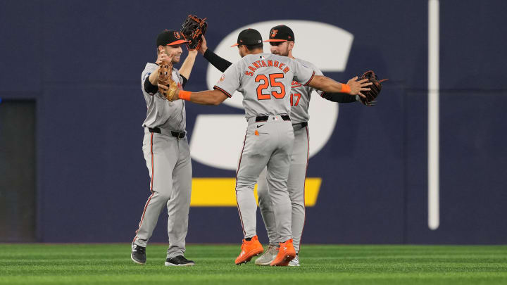 Aug 7, 2024; Toronto, Ontario, CAN; Baltimore Orioles left ielder Austin Slater (15) and center fielder Colton Cowser (17) and right fielder Anthony Santander (25) celebrate the win against the Toronto Blue Jays at the end of he ninth inning at Rogers Centre.