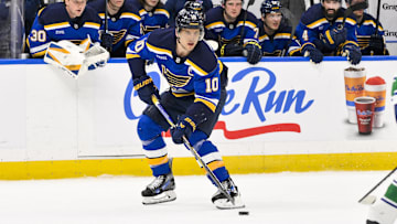 Mar 20, 2025; St. Louis, Missouri, USA;  St. Louis Blues center Brayden Schenn (10) controls the puck against the Vancouver Canucks during overtime at Enterprise Center. Mandatory Credit: Jeff Curry-Imagn Images